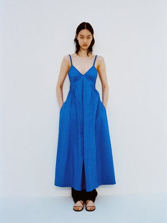 Image of model standing against a white backdrop, wearing Barker Dress in Stretch Poplin in Cyan