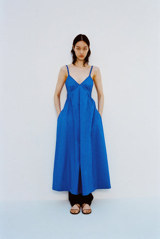 Image of model standing against a white backdrop, wearing Barker Dress in Stretch Poplin in Cyan