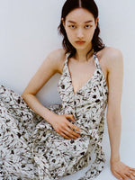 Cropped image of model sitting against white backdrop wearing the Rhea Dress in Printed Poplin in Light Butter/Black.