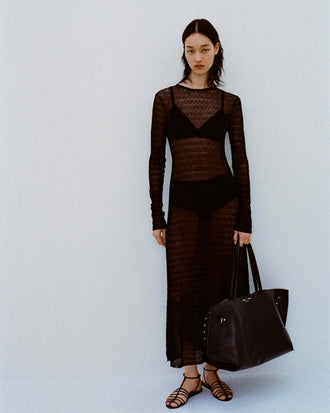 Image of model against white backdrop wearing the Miriam Dress in Crochet in Black