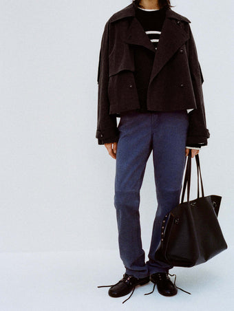 Cropped image of model against white backdrop wearing Nia Sweater in Bobble Boucle in Black/White and the Maxine Pant in Suede in Slate