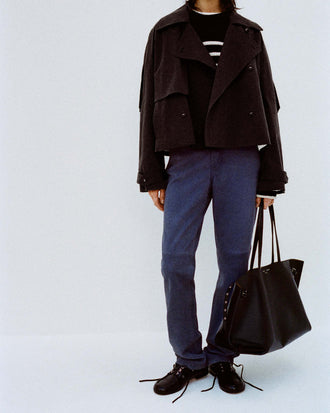 Cropped image of model against white backdrop wearing Nia Sweater in Bobble Boucle in Black/White and the Maxine Pant in Suede in Slate