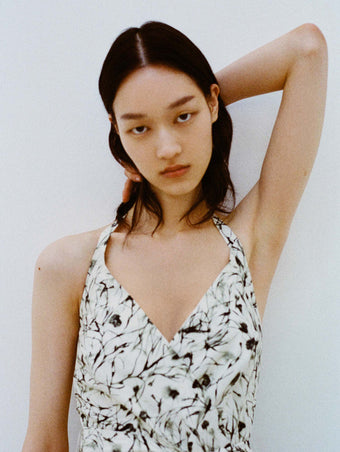Cropped image of model standing against white backdrop wearing the Rhea Dress in Printed Poplin in Light Butter/Black.
