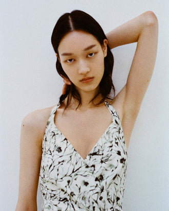 Cropped image of model standing against white backdrop wearing the Rhea Dress in Printed Poplin in Light Butter/Black.