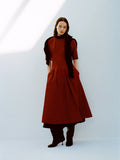 Model wearing Ainsley Dress in Tech Cotton in Claret with a black scarf on shoulders against a white background