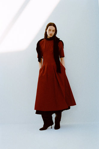 Model wearing Ainsley Dress in Tech Cotton in Claret with a black scarf on shoulders against a white background