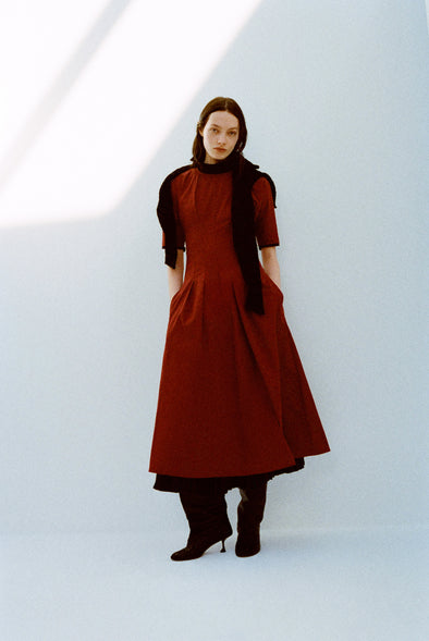 Model wearing Ainsley Dress in Tech Cotton in Claret with a black scarf on shoulders against a white background