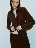 Image of model wearing Maddi Shirt in Merino Wool Twill in Chocolate over a white shirt against a light blue background