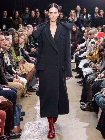 Model Walking in Proenza Schouler Fall Winter 2024 Runway Show Wearing Reed Coat in Charcoal Brushed Wool, Silo Bag in Black Nappa, and  Monogram Loafers in Rosewood Shiny Eel