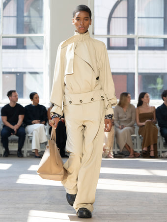 Image of model walking Proenza Schouler SS25 Runway wearing Adrien Jacket in Fluid Viscose in Sand and Emmeline Shirt in Printed Silk Viscose in Black Multi and Darya Pant in Fluid Viscose in Sand and Days Carryall in Cumin Smooth Calf in CUMIN and Chelsea Boot in Black