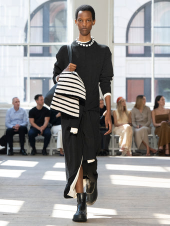 Image of model walking Proenza Schouler SS25 Runway wearing Luca Dress in Silk Cotton Crepe Knit in Black and Luca Dress in Silk Cotton Crepe Knit in Off White and Days Tote in Black Pebbled Calf Skin in BLACK and Caribou Chelsea Boot in Black