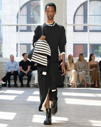 Image of model walking Proenza Schouler SS25 Runway wearing Luca Dress in Silk Cotton Crepe Knit in Black and Luca Dress in Silk Cotton Crepe Knit in Off White and Days Tote in Black Pebbled Calf Skin in BLACK and Caribou Chelsea Boot in Black