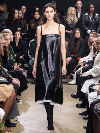 Model Walking in Proenza Schouler Fall Winter 2024 Runway Show Wearing Ivonne Dress in Black Polished Nappa and Tee Over the Knee Boots in Black Viscose Knit