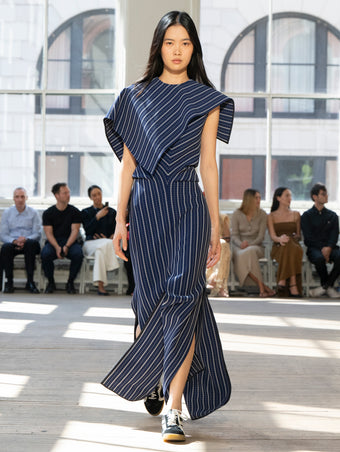 Image of model walking Proenza Schouler SS25 Runway wearing Selene Dress in Plaid Bi-Stretch Viscose in Cobalt Multi and Track Sneaker in BLACK/WHITE