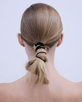 image of the back of a model's head with a blonde ponytail wrapped in black rubber band