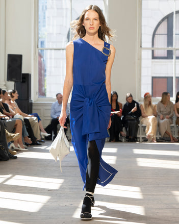 Image of model walking Proenza Schouler SS25 Runway wearing Jackie Dress in Technical Nylon Jacquard in Cobalt and Tetra Shoulder Bag in Smoke Nappa in SMOKE and Slash Tie Sandal in WHITE