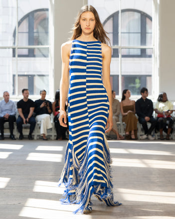 Image of model walking Proenza Schouler SS25 Runway wearing Yves Dress in Stripe Fringed Knit in Cobalt Multi and Track Sneaker in COBALT