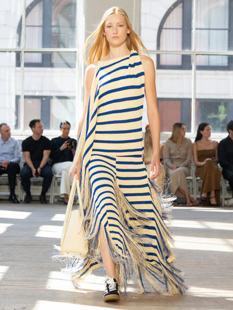 Image of model walking Proenza Schouler SS25 Runway wearing Yves Top in Stripe Fringed Knit in Pale Yellow Multi and Tate Bag in Manilla Smooth Calf in MANILLA and Track Sneaker in BLACK/WHITE