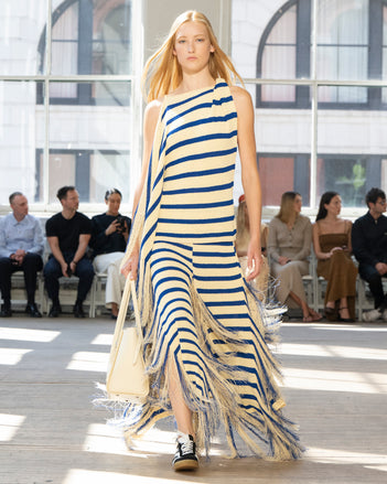 Image of model walking Proenza Schouler SS25 Runway wearing Yves Top in Stripe Fringed Knit in Pale Yellow Multi and Tate Bag in Manilla Smooth Calf in MANILLA and Track Sneaker in BLACK/WHITE