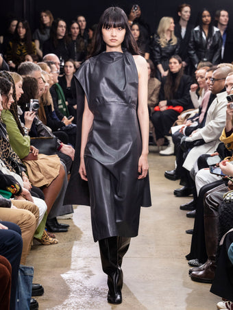 Model Walking in Proenza Schouler Fall Winter 2024 Runway Show Wearing Maude Dress in Graphite Nappa and Tee Knee High Boots in Black Nappa