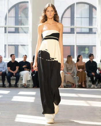 Image of model walking Proenza Schouler SS25 Runway wearing Ophelia Dress in Printed Marocaine in Black Multi and Weyes Pant in Matte Viscose Crepe in White and Caribou Mule in WHITE