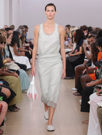 Model Walking Proenza Schouler Ss24 Runway In Mona Dress In Smoke/white Silk Nylon, Net Sling Bag In Optic White Tulle, Soft Square Perforated Slippers In Cream Soft Calf