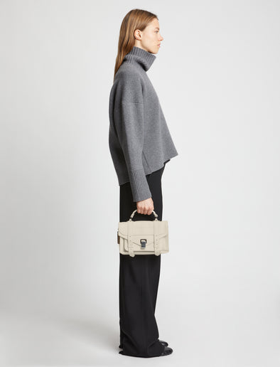 Image of model carrying PS1 Tiny Bag in CLAY in hand