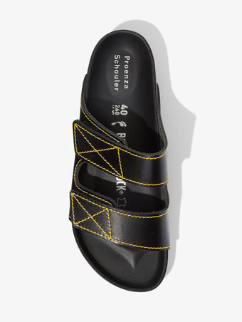 Proenza Schouler aerial image of Birkenstock collaboration Arizona Slides in black with yellow contrast stitching