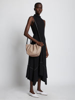 Image of model carrying Small Ruched Crossbody Tote in LIGHT TAUPE