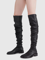 Image of model wearing ruched thigh-high boots in Black