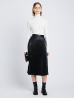 Front image of model in Faux Leather Pleated Skirt in black
