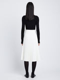 Back image of model in Faux Leather Pleated Skirt in white