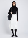 Front image of model in Faux Leather Pleated Skirt in white