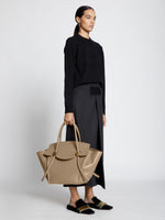 Image of model carrying Pipe Bag in LIGHT TAUPE