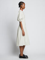 Side full length image of model wearing Faux Leather Puff Sleeve Dress in OFF WHITE