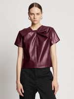 Front cropped image of model wearing Faux Leather Twisted Top in PLUM