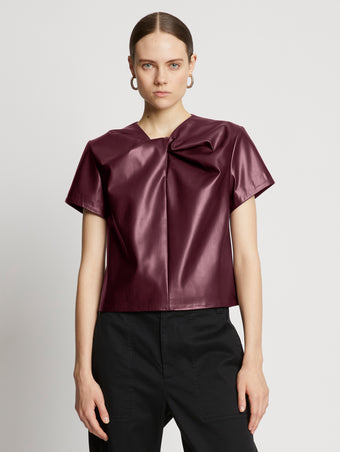 Front cropped image of model wearing Faux Leather Twisted Top in PLUM