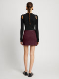 Back full length image of model wearing Faux Leather Smocked Mini Skirt in PLUM