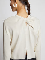 Detail image of model wearing Twist Long Sleeve Sweater in CREAM