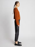 Side full length image of model wearing Twist Long Sleeve Sweater in HONEY