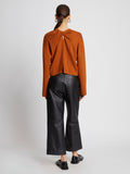 Back full length image of model wearing Twist Long Sleeve Sweater in HONEY