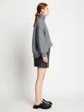 Side full length image of model wearing Faux Leather Mini Skirt in BLACK