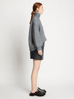Side full length image of model wearing Faux Leather Mini Skirt in BLACK