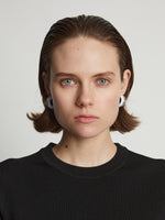 Proenza Schouler Image of model wearing mini hoop earrings in optic white