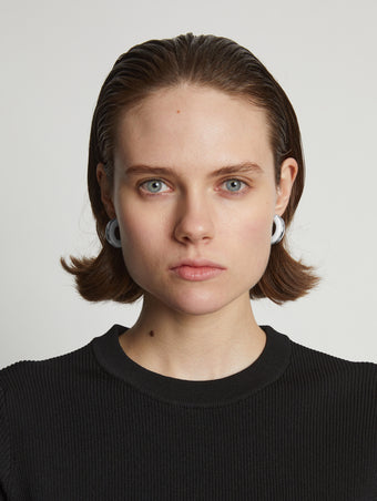 Proenza Schouler Image of model wearing mini hoop earrings in optic white