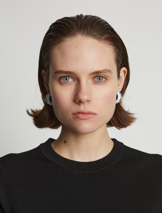 Proenza Schouler Image of model wearing mini hoop earrings in optic white