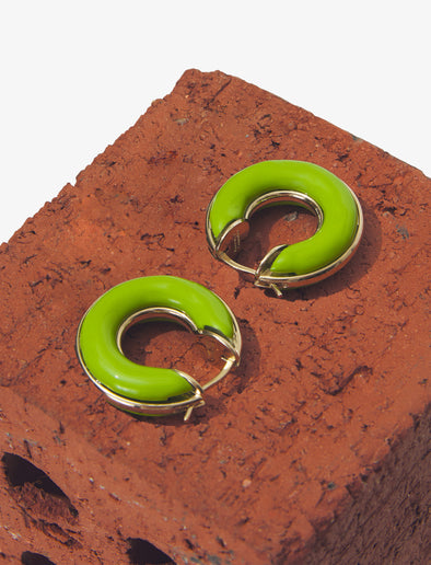 Image of mini hoop earrings in sulphur against brick
