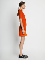 Side full length image of model wearing Compact Viscose Knit Top in TANGERINE