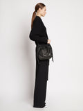 Side image of model carrying Drawstring Pouch in BLACK