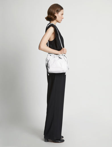 Image of model carrying Drawstring Pouch in OPTIC WHITE
